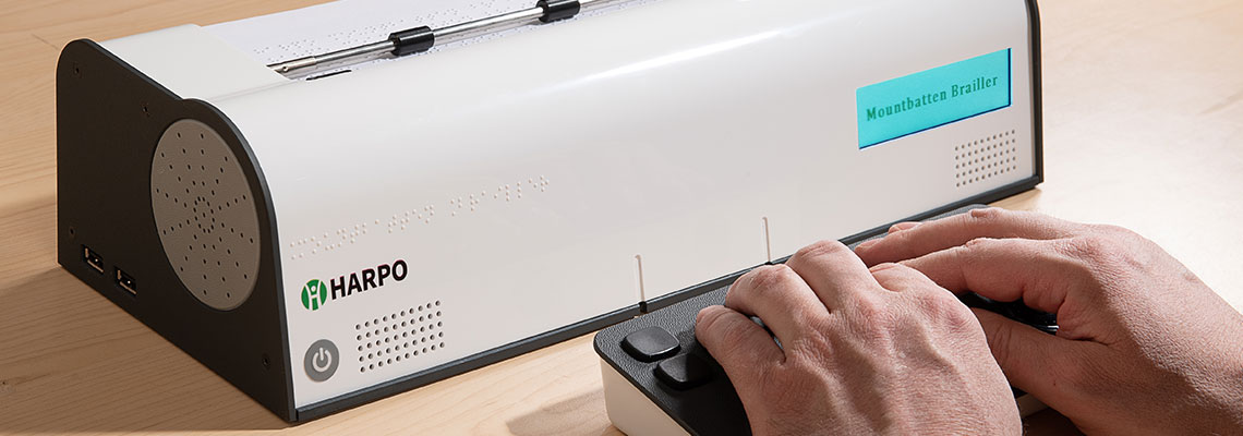 Mountbatten Brailler Tutor showing showing hands on Braille Keyboard