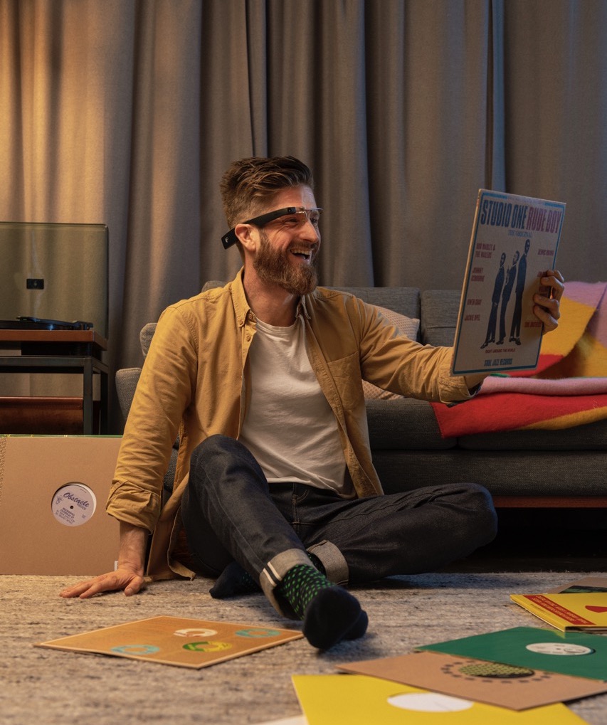 Image of man reading a record player using the Envision Glasses, wearables for low vision and blind 