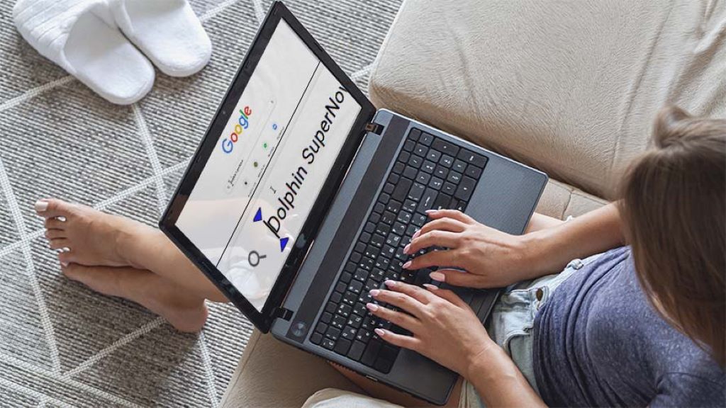 Image of person sitting on a couch using Dolphin SuperNova to enlarge their Google browser search bar