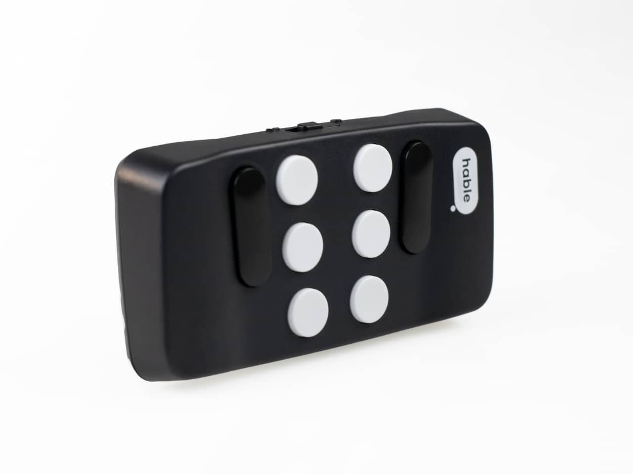 photo of the hable device from the front - a small black remote like size device with 6 white braille keys and 2 black rocker bars on either side