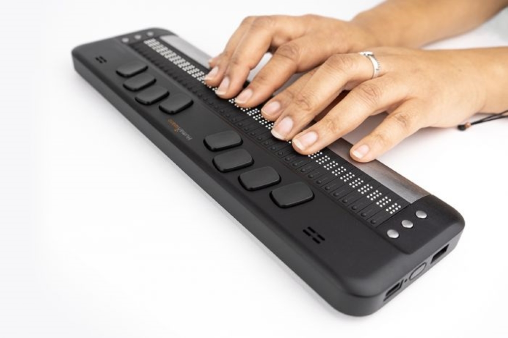 close of image of a person with their hands on the brailliant bi 40x reading the braille display